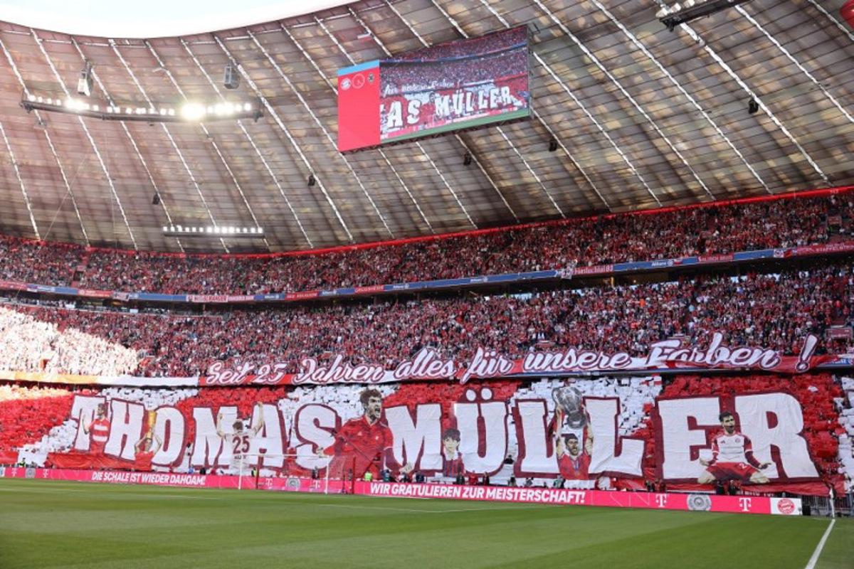 Fans display banner depicting outgoing Bayern Munich's German forward #25 Thomas Mueller ahead the German first division Bundesliga football match between Bayern Munich and Borussia Moenchengladbach in Munich on May 10, 2025.  Alexandra BEIER / AFP