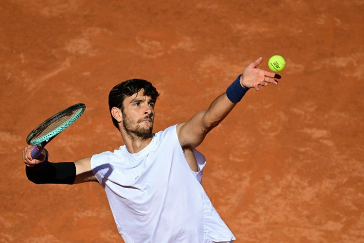 Italy's Lorenzo Musetti serves to Spain's Carlos Alcaraz during their men's singles semi-final match for the ATP Rome Open tennis tournament at Foro Italico in Rome on May 16, 2025.   Tiziana FABI / AFP
