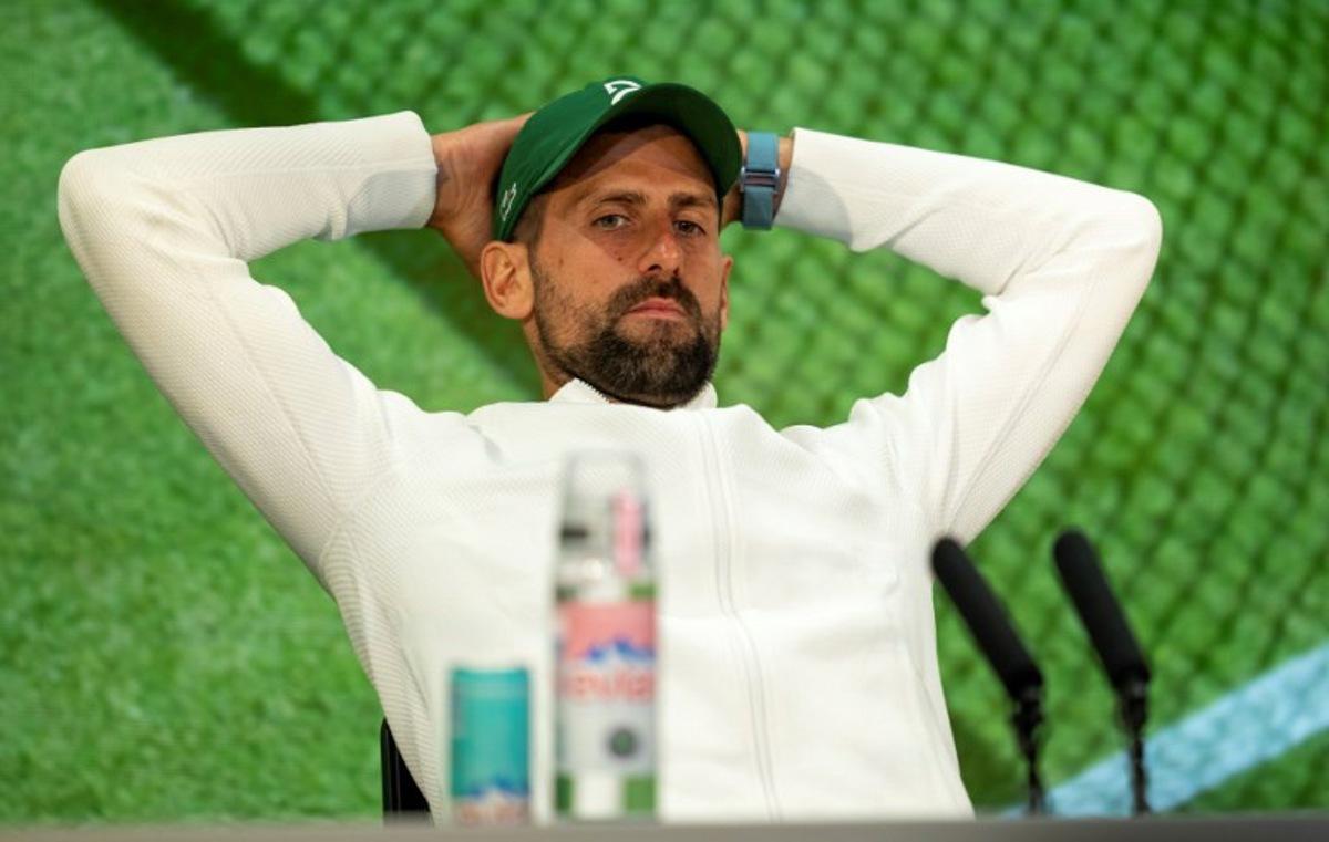 Serbia's Novak Djokovic reacts as he speaks to the media during a post-match press conference in the Media Theatre in the Broadcast Centre after his defeat in the men's singles semi-final tennis match against Italy's Jannik Sinner on the twelfth day of the 2025 Wimbledon Championships at The All England Lawn Tennis and Croquet Club in Wimbledon, southwest London, on July 11, 2025.   Benjamin Gilbert / AELTC / POOL / AFP