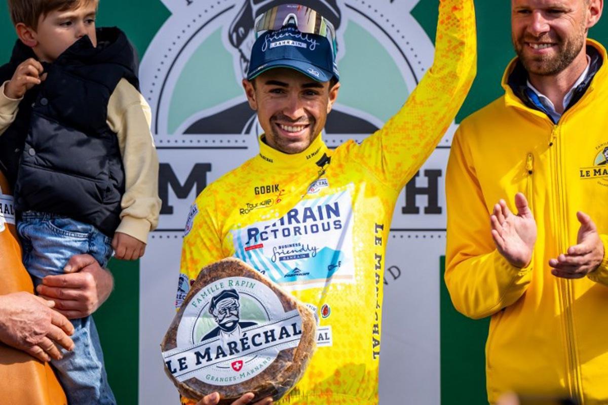 France's Lenny Martinez (C) celebrates winning the fourth stage and holding the yellow jersey of the Tour of Romandie UCI cycling World tour, a 128,4 km from Sion to Thyon 2000, in Thyon, on May 3, 2025.   Maxime SCHMID / AFP