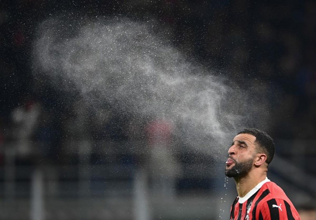 Milan's British defender #32 Kyle Andrew Zac Walker spits water during the Italian Cup semi-final first leg football match between AC Milan and Inter Milan at San Siro stadium in Milan, on April 2, 2025.  Isabella BONOTTO / AFP