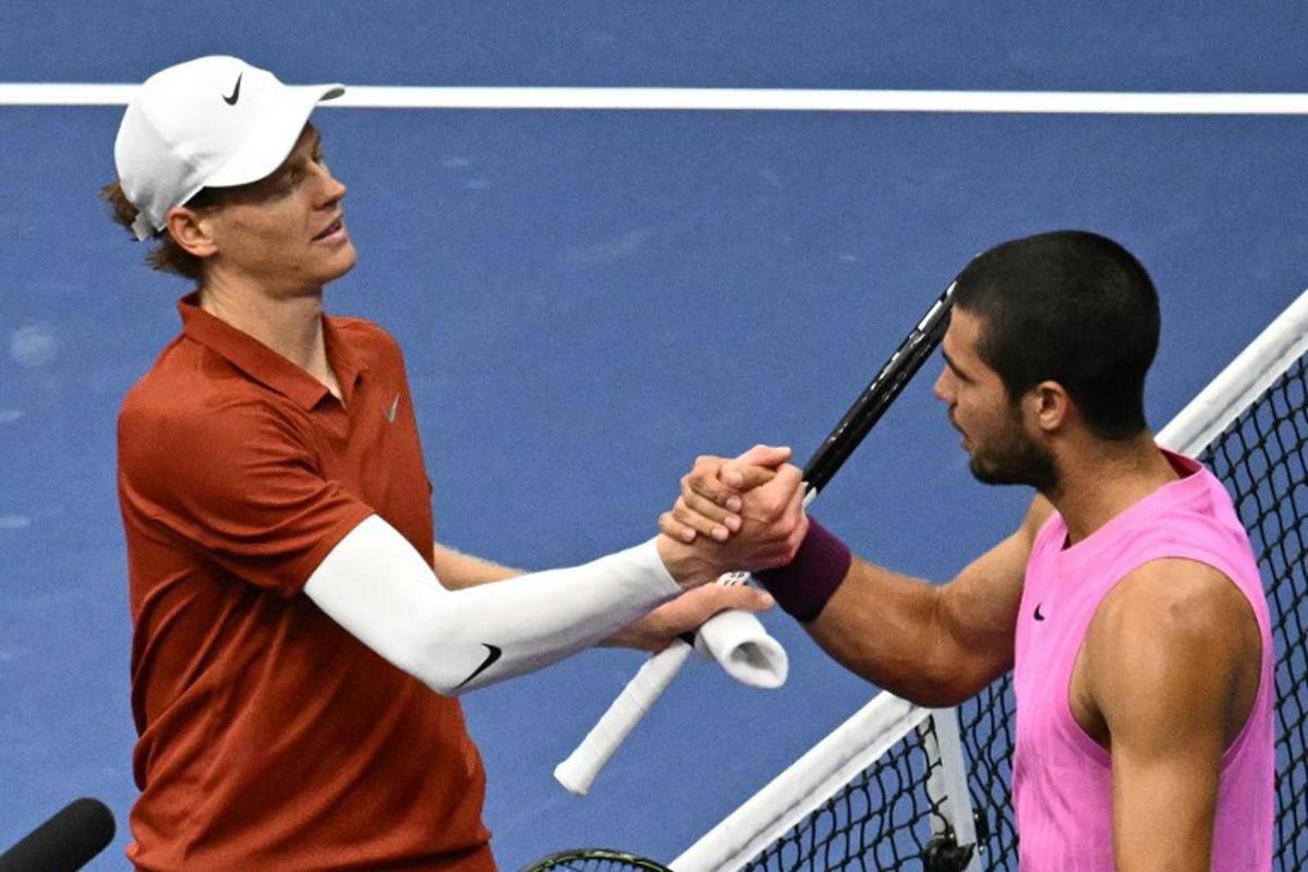 Italy's Jannik Sinner (L) and Spain's Carlos Alcaraz shake hands at the net after alcaraz won the men's singles final tennis match on day fifteen of the US Open tennis tournament at the USTA Billie Jean King National Tennis Center in New York City on September 7, 2025.  Mandel NGAN / AFP