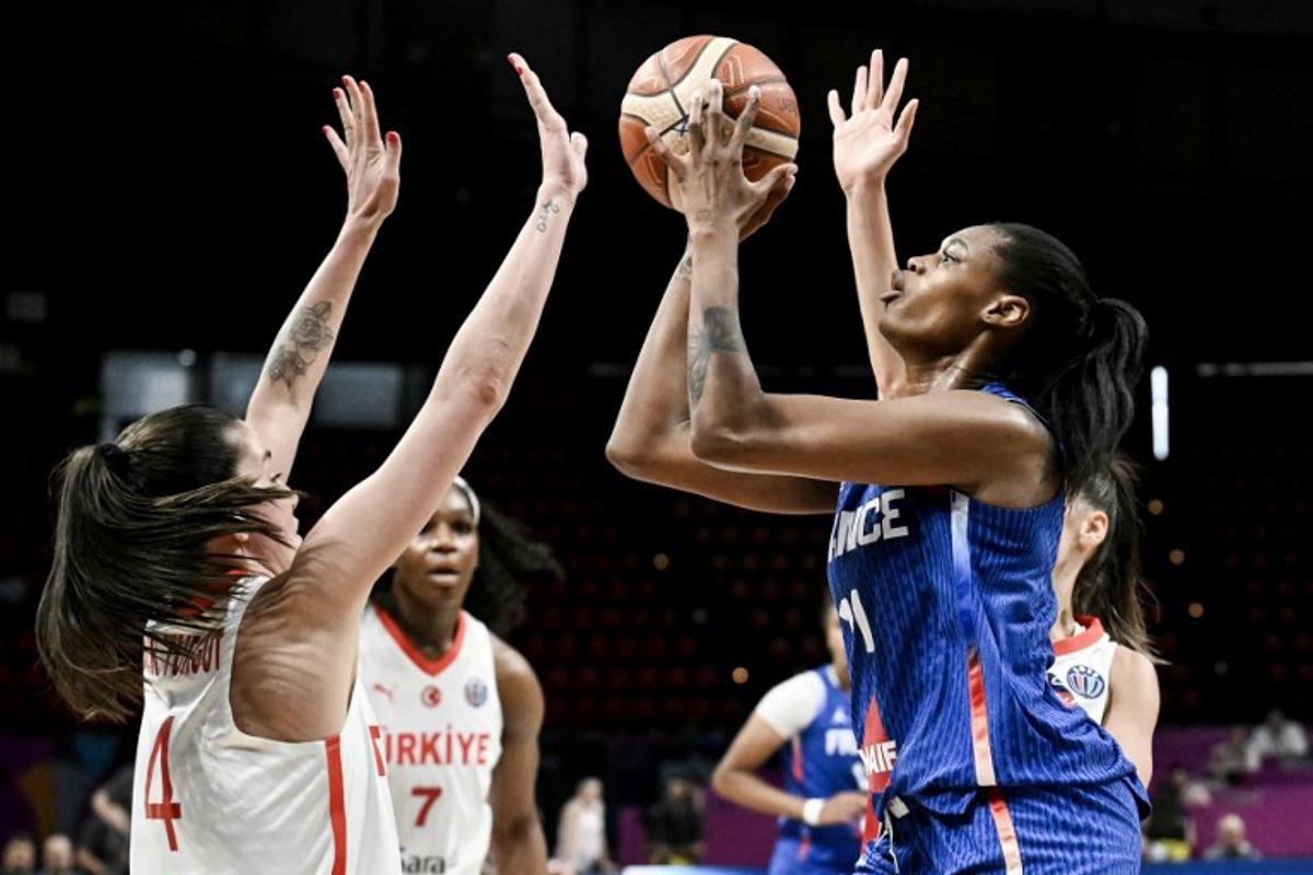 France's small forward Valeriane Ayayi (R) shoots in front of Turkey's point guard Olcay Cakir (L) during the FIBA Women's EuroBasket 2025 match between France and Turkey at the Peace and Friendship Stadium in Athens on June 18, 2025.   Angelos Tzortzinis / AFP