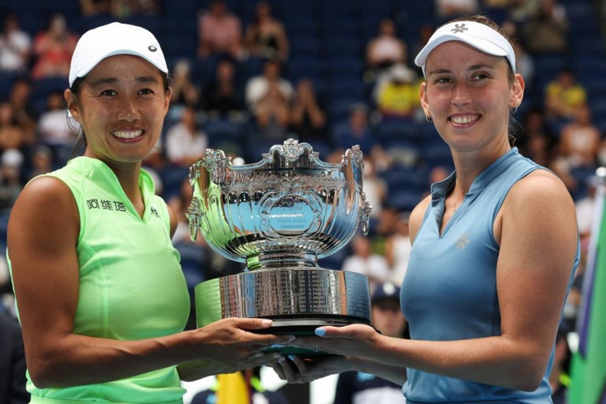 China's Zhang Shuai (L) and partner Belgium's Elise Mertens pose with the winners' trophy after their victory in their women's doubles final match against Kazakhstan's Anna Danilina and Serbia's Aleksandra Krunic on day fourteen of the Australian Open tennis tournament in Melbourne on January 31, 2026.  DAVID GRAY / AFP