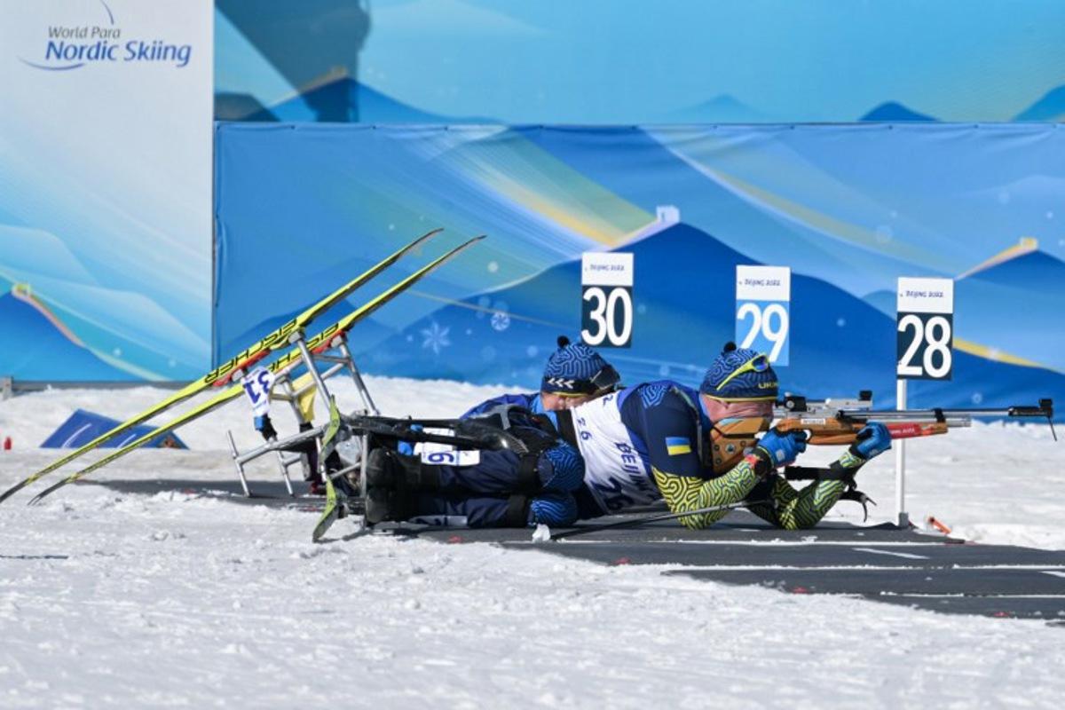 Ukraine's Maksym Yarovyi (R) and Pavlo Bal (L) compete in the men's middle distance sitting para biathlon final event on March 8, 2022 at the Zhangjiakou National Biathlon Centre, during the Beijing 2022 Winter Paralympic Games.  Mohd Rasfan / AFP
