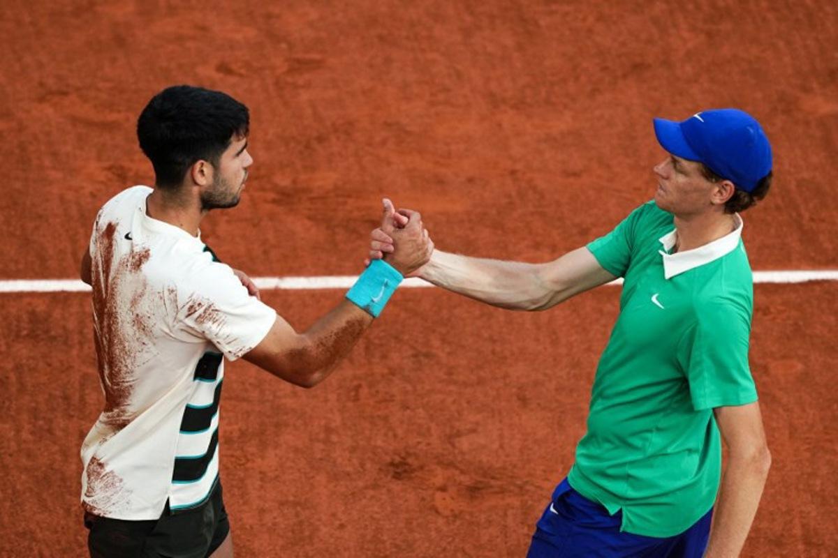 Spain's Carlos Alcaraz (L) shakes hands with Italy's Jannik Sinner after winning the men's singles final match on day 15 of the French Open tennis tournament on Court Philippe-Chatrier at the Roland-Garros Complex in Paris on June 8, 2025.  Dimitar DILKOFF / AFP