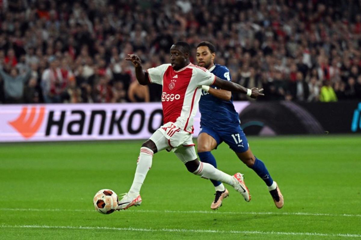 Ajax' forward #11 Portuguese Carlos Forbs (L) fights for the ball with Marseille's Italian-Brazilian defender #12 Renan Lodi (R) during the Europa League Group B football match between AFC Ajax and Olympique Marseille at Johan Cruijff ArenA in Amsterdam, on September 21, 2023.  Olaf Kraak / ANP / AFP