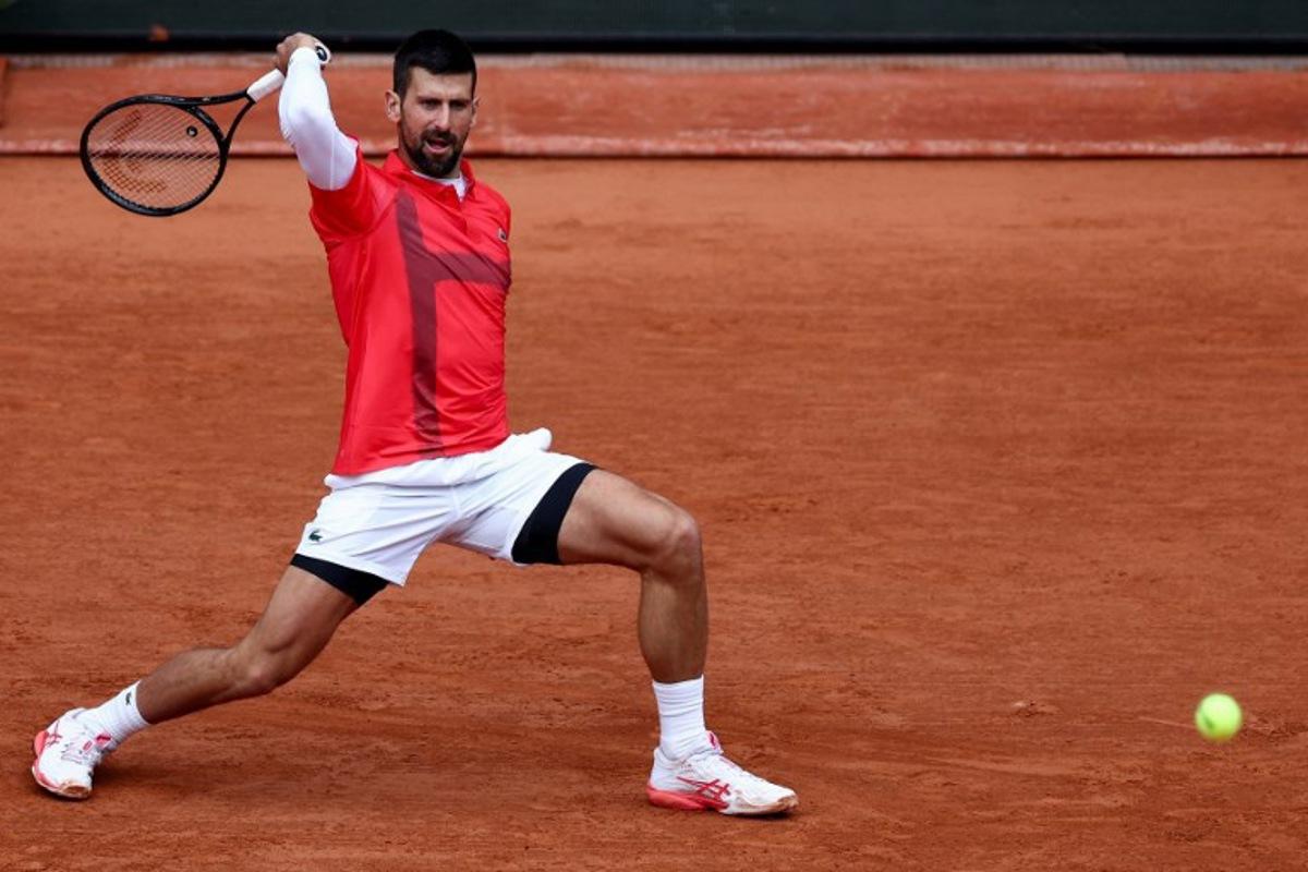 Serbia's Novak Djokovic plays a backhand return to US Mackenzie Mcdonald during their men's singles match on day 3 of the French Open tennis tournament on Court Philippe-Chatrier at the Roland-Garros Complex in Paris on May 27, 2025.  FRANCK FIFE / AFP