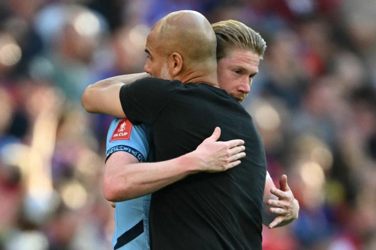 Manchester City's Spanish manager Pep Guardiola (R) embraces Manchester City's Belgian midfielder #17 Kevin De Bruyne (L) on the pitch after the English FA Cup final football match between Crystal Palace and Manchester City at Wembley stadium in London, on May 17, 2025. Crystal Palace beat Manchester City 1-0 in the FA Cup final at Wembley on Saturday to win the first major trophy in the club's history. Glyn KIRK / AFP