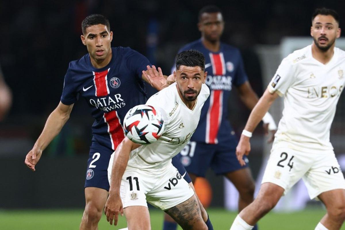 Nice's French midfielder #11 Morgan Sanson (C) fights for the ball with Paris Saint-Germain's Moroccan defender #02 Achraf Hakimi (L)  during the French L1 football match between Paris Saint-Germain (PSG) and OGC Nice at the Parc des Princes stadium in Paris, on April 25, 2025.  FRANCK FIFE / AFP