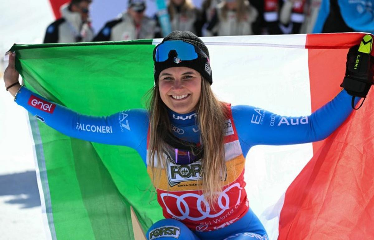 Winner Italy's Laura Pirovano poses with the Italian flag after the Women's Downhill race of the FIS Ski World Cup at the La Volata slope in the Passo San Pellegrino ski area, Val di Fassa, Italy on March 7, 2026.  Andreas SOLARO / AFP