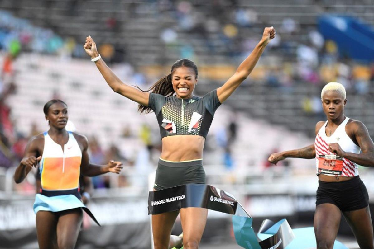 USA'S Gabrielle Thomas (C) of team New Balance crosses the finish line in first place, alognside Britain's Dina Asher Smith (L) and Bahrain's Salwa Eid Naser (R) in the women's 200 meter dash long sprint during the Grand Slam Track competition at the National Stadium in Kingston, Jamaica on April 4, 2025.  Ricardo Makyn / AFP