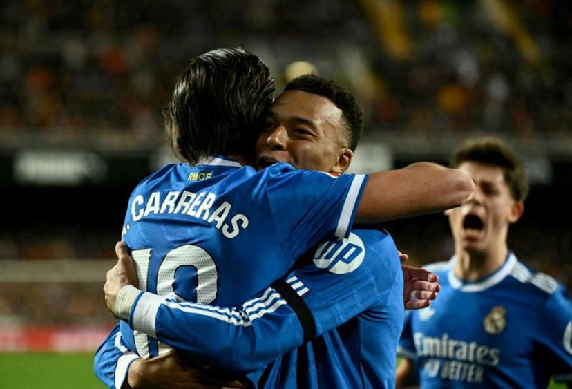 Real Madrid's Spanish defender #18 Alvaro Carreras celebrates with Real Madrid's French forward #10 Kylian Mbappe scoring his team's first goal during the Spanish league football match between Valencia CF and Real Madrid CF at Mestalla Stadium in Valencia on February 8, 2026.  JOSE JORDAN / AFP