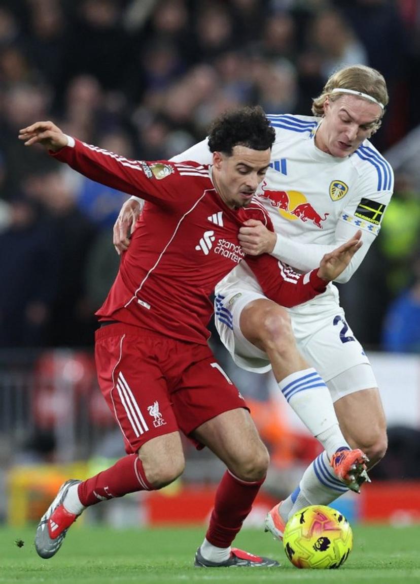Leeds United's Belgian defender #23 Sebastiaan Bornauw (R) tries to tackle Liverpool's English midfielder #17 Curtis Jones (L) during the English Premier League football match between Liverpool and Leeds United at Anfield in Liverpool, north west England on January 1, 2026.  Darren Staples / AFP