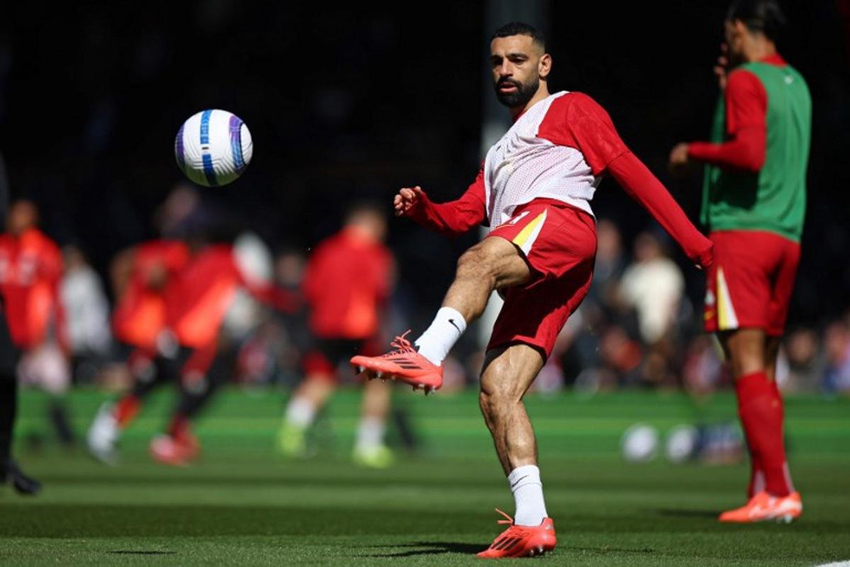 Liverpool's Egyptian striker #11 Mohamed Salah warms up ahead of the English Premier League football match between Fulham and Liverpool at Craven Cottage in London on April 6, 2025.  HENRY NICHOLLS / AFP