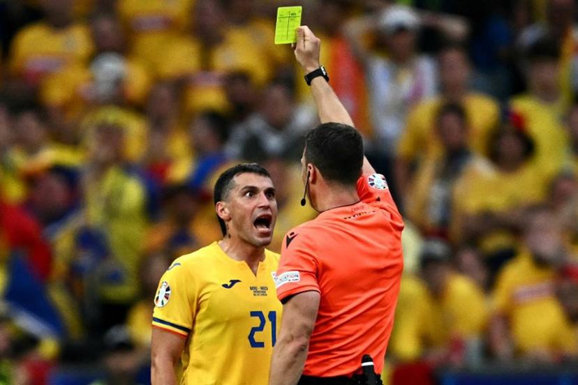 German referee Felix Zwayer shows a yellow card to Romania's midfielder #21 Nicolae Stanciu during the UEFA Euro 2024 round of 16 football match between Romania and the Netherlands at the Munich Football Arena in Munich on July 2, 2024.  Fabrice COFFRINI / AFP