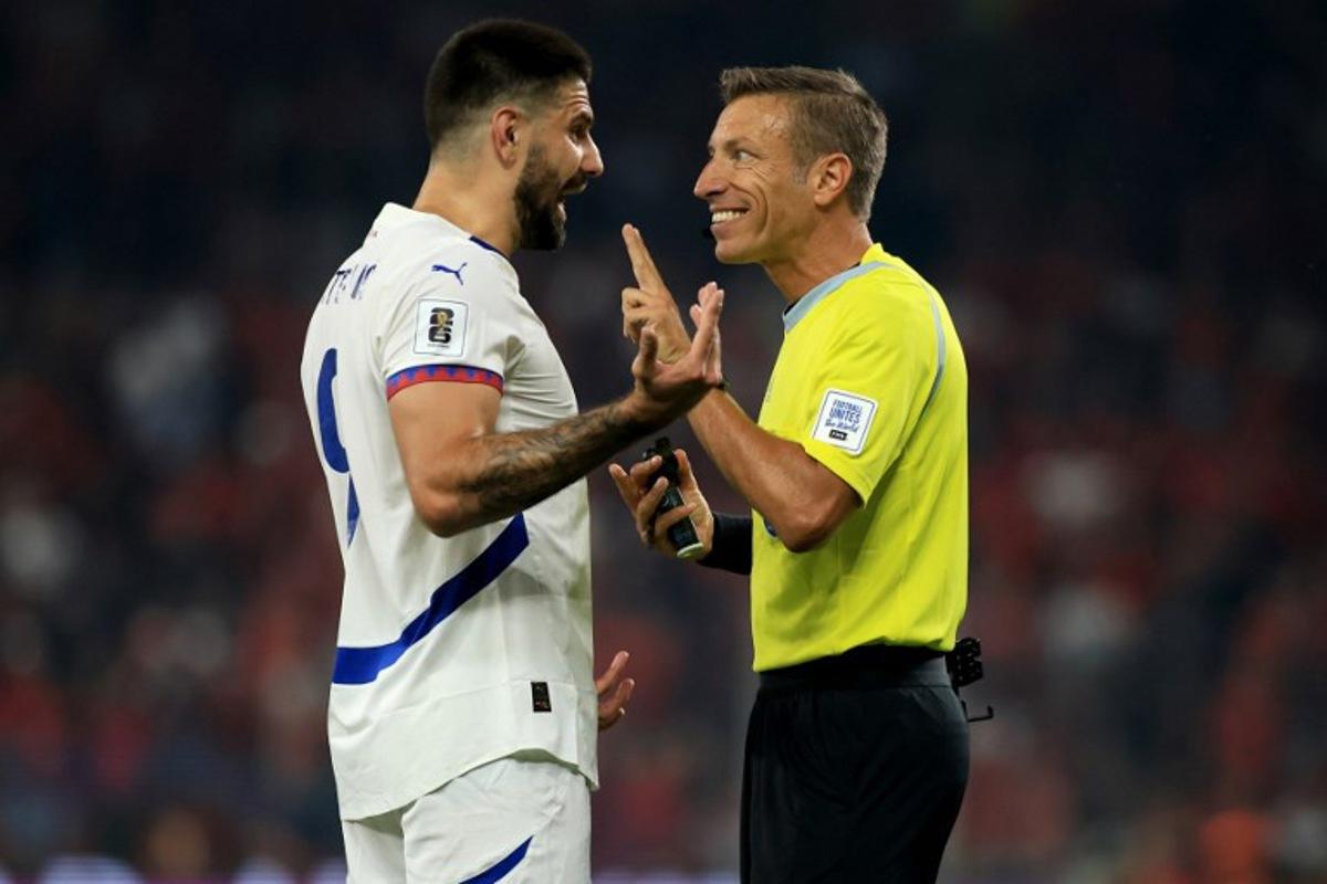 Serbia's forward #09 Aleksandar Mitrovic (L) talks to Italian referee Davide Massa during the 2026 World Cup qualifiers Europe zone, 1st round group K football match between Albania and Serbia at the Air Albania Stadium in Tirana on June 7, 2025.  Adnan Beci / AFP