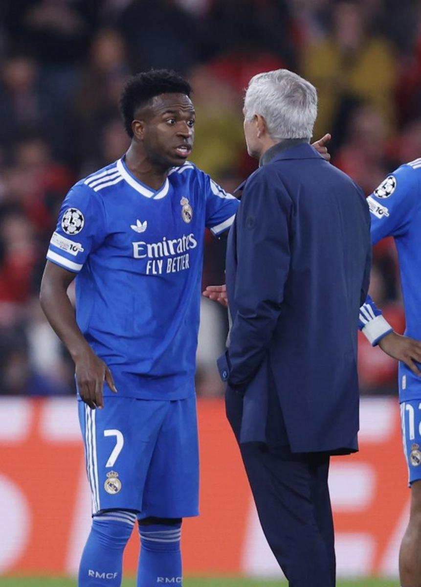 Real Madrid's Brazilian forward #07 Vinicius Junior talks with SL Benfica's Portuguese head coach Jose Mourinho after listening racists insults during the UEFA Champions League knockout round play-off first leg football match between SL Benfica and Real Madrid CF at Estadio da Luz in Lisbon on February 17, 2026.  FILIPE AMORIM / AFP