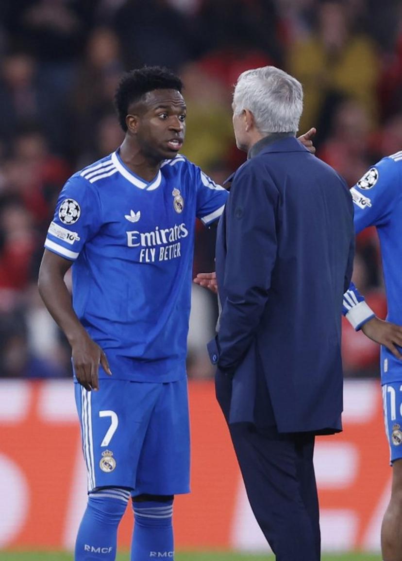 Real Madrid's Brazilian forward #07 Vinicius Junior talks with SL Benfica's Portuguese head coach Jose Mourinho after listening racists insults during the UEFA Champions League knockout round play-off first leg football match between SL Benfica and Real Madrid CF at Estadio da Luz in Lisbon on February 17, 2026.  FILIPE AMORIM / AFP