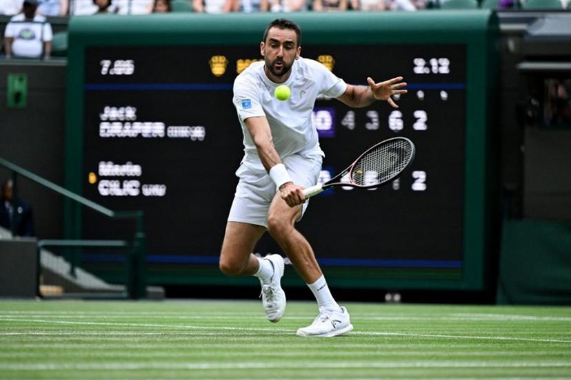 Croatia's Marin Cilic plays a backhand return to Britain's Jack Draper during their men's singles second round tennis match on the fourth day of the 2025 Wimbledon Championships at The All England Lawn Tennis and Croquet Club in Wimbledon, southwest London, on July 3, 2025.  Kirill KUDRYAVTSEV / AFP