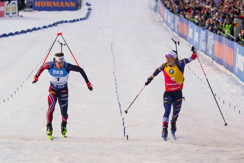 Norway's Sturla Holm Laegreid (L) crosses the finish line to win as France's Eric Perrot (R) comes in to place second during the men's 12,5km pursuit event of the IBU Biathlon World Cup in Holmenkollen, Oslo on March 21, 2026.  Thomas Fure / NTB / AFP