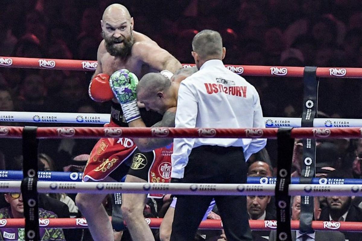 Britain's Tyson Fury (red) and Ukraine's Oleksandr Usyk (blue) compete during their heavyweight world championship rematch at the Kingdom Arena in Riyadh on December 22, 2024.  AFP