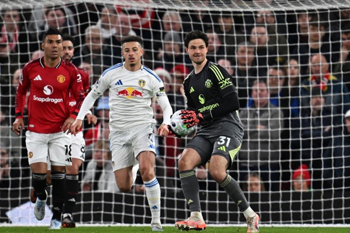 Manchester United's Belgian goalkeeper #31 Senne Lammens (R) prepares to throw the ball during the English Premier League football match between Manchester United and Leeds United at Old Trafford in Manchester, north west England, on April 13, 2026.  Paul ELLIS / AFP