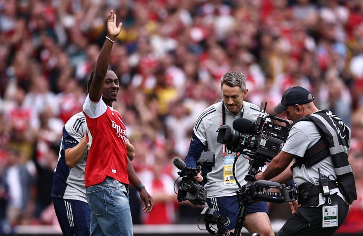 Eberechi Eze waves to the crowd as he is unveiled as a new signing ahead of the English Premier League football match between Arsenal and Leeds United at the Emirates Stadium in London on August 23, 2025.   HENRY NICHOLLS / AFP