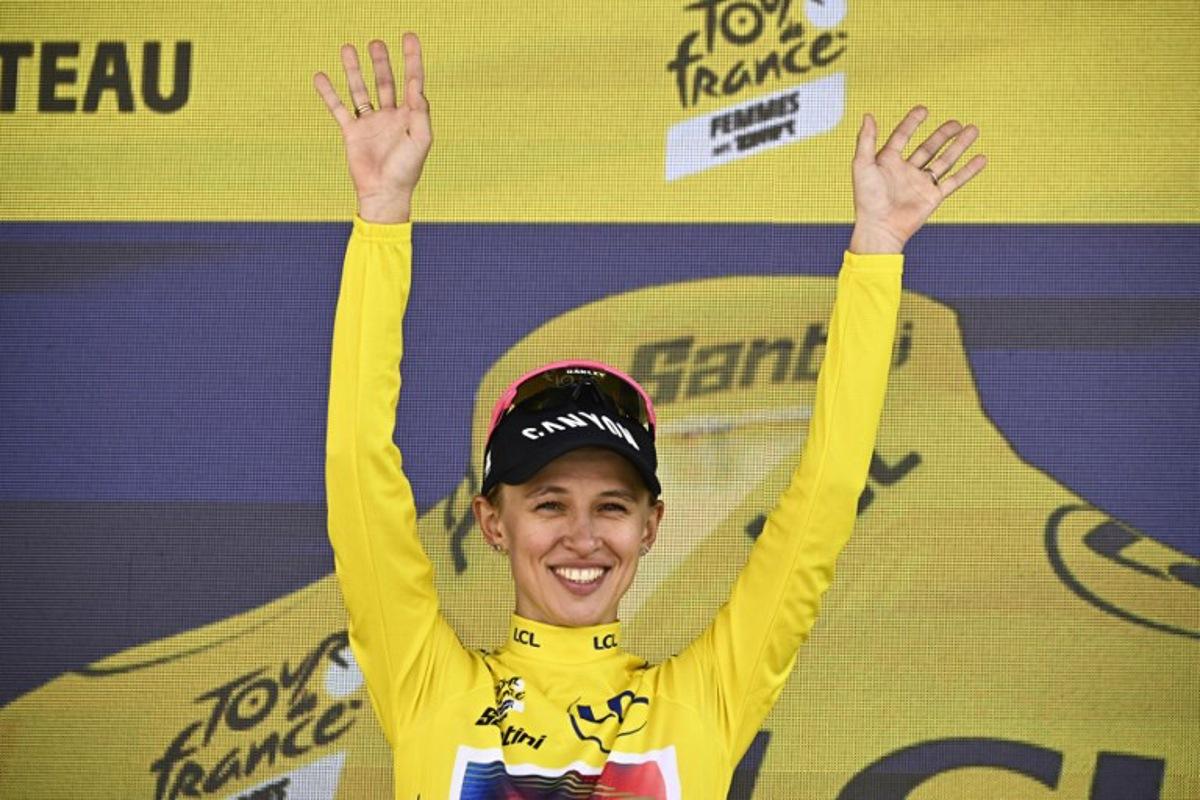 Canyon//SRAM Racing team's Polish rider Katarzyna Niewiadoma celebrates her overall leader's yellow jersey on the podium after the 6th stage (out of 8) of the third edition of the Women's Tour de France cycling race, a 159.2 km between Remiremont and Morteau, eastern France, on August 16, 2024.  JULIEN DE ROSA / AFP