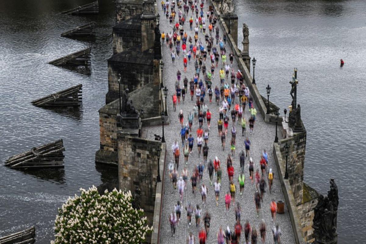 Participants run across the Charles Bridge as they take part in the Prague's international marathon on May 4, 2025 in Prague, Czech Republic.   Michal Cizek / AFP