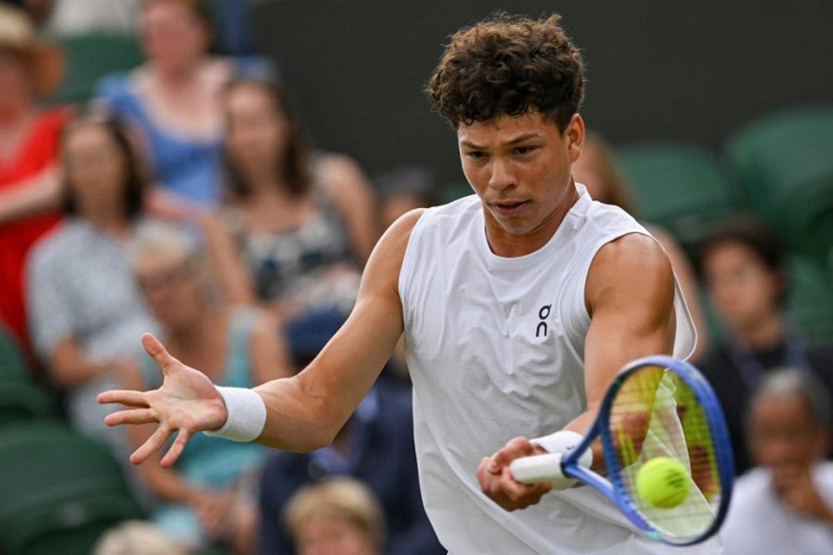 US Ben Shelton plays a forehand return to Australia's Rinky Hijikata during their men's singles second round tennis match on the fourth day of the 2025 Wimbledon Championships at The All England Lawn Tennis and Croquet Club in Wimbledon, southwest London, on July 3, 2025.  Glyn KIRK / AFP
