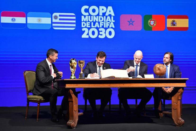 Conmebol's President Alejandro Dominguez (L-2) and FIFA President Gianni Infantino (R-2), accompanied by Paraguay's President Santiago Peña (L) and Uruguay's President Luis Lacalle(R), sign a book of minutes of the 2030 World Cup during Conmebol's 78th Ordinary Congress in Luque, Paraguay on April 11, 2024.  NORBERTO DUARTE / AFP
