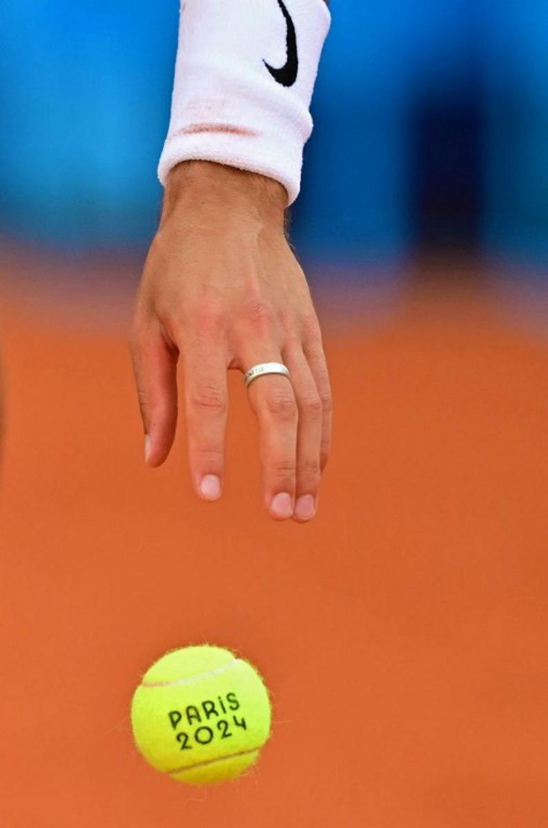 Italy's Lorenzo Musetti prepares to serve while playing France's Gael Monfils during their men's singles first round tennis match on Court Suzanne-Lenglen at the Roland-Garros Stadium at the Paris 2024 Olympic Games, in Paris on July 28, 2024.   Martin  BERNETTI / AFP
