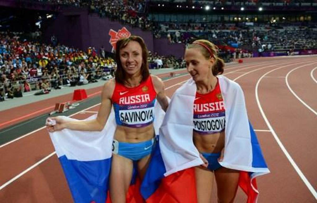Russia's gold medalist Mariya Savinova (L) celebrates with Russia's bronze medalist Ekaterina Poistogova (R) after winning the women's 800m final at the athletics event of the London 2012 Olympic Games on August 11, 2012 in London.  AFP PHOTO / FRANCK FIFE