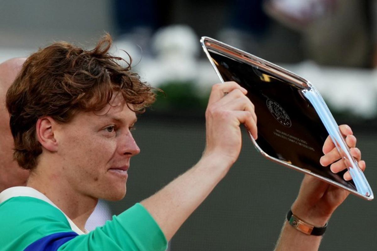 Second-placed Italy's Jannik Sinner holds his trophy after his defeat in the men's singles final match against Spain's Carlos Alcaraz on day 15 of the French Open tennis tournament on Court Philippe-Chatrier at the Roland-Garros Complex in Paris on June 8, 2025.  Dimitar DILKOFF / AFP