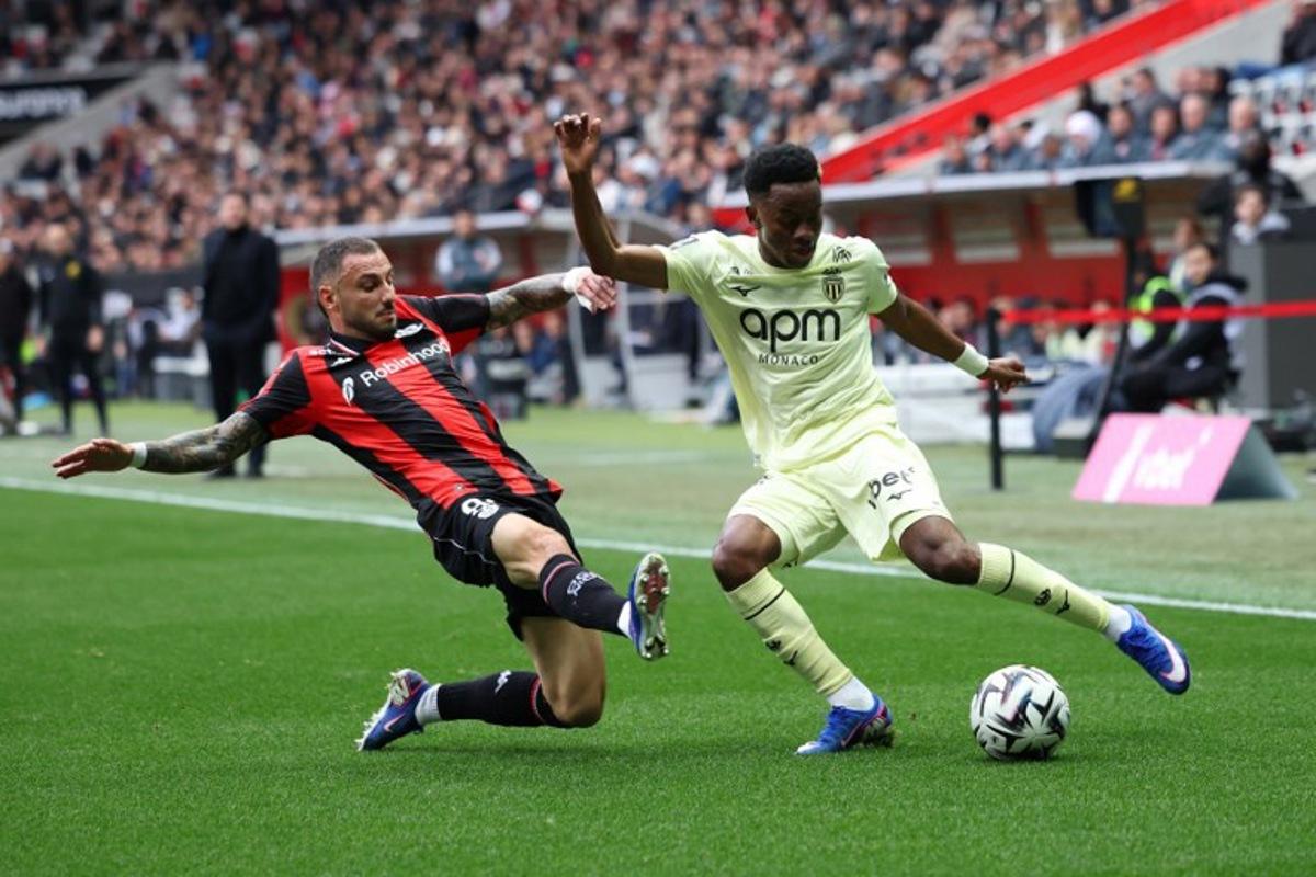 Nice's French defender #92 Jonathan Clauss (L) fights for the ball with Monaco's Simon Adingra (R) during the French L1 football match between OGC Nice and AS Monaco at the Allianz Riviera Stadium in Nice, south-eastern France on February 8, 2026.   Valery HACHE / AFP