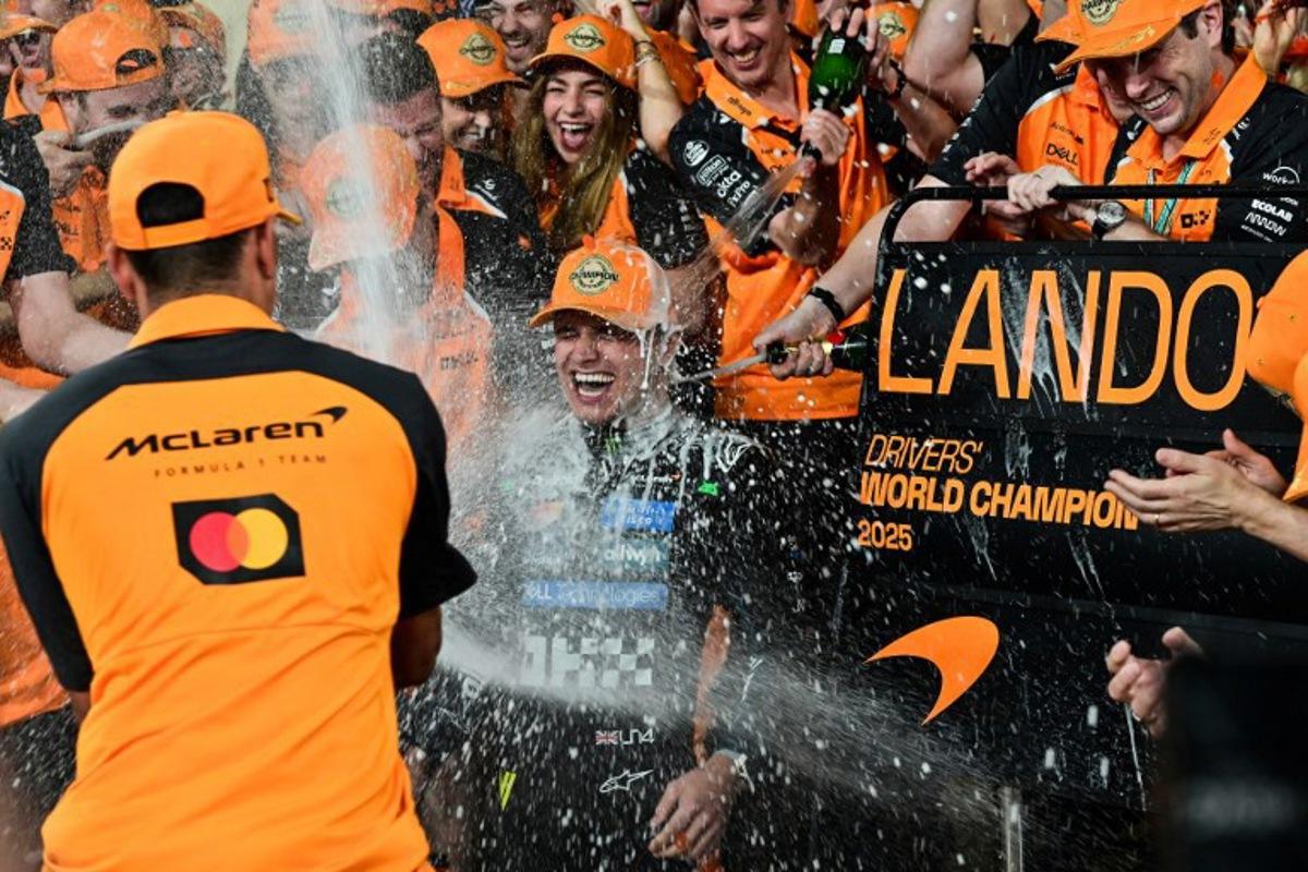 World champion and race third-placed McLaren's British driver Lando Norris (C) celebrates with his team at the end of the Abu Dhabi Formula One Grand Prix at the Yas Marina Circuit in Abu Dhabi on December 7, 2025.  GIUSEPPE CACACE / AFP