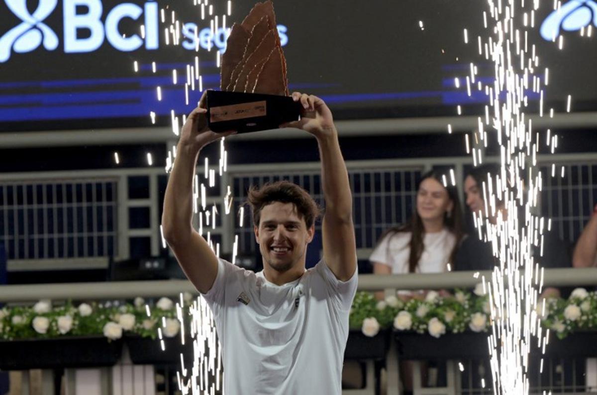 Italy's Luciano Darderi lifts the trophy after winning the ATP Santiago Open men's singles tennis final match against Germany's Yannick Hanfmann at the Club San Carlos de Apoquindo in Santiago on March 1, 2026.  Rodrigo ARANGUA / AFP