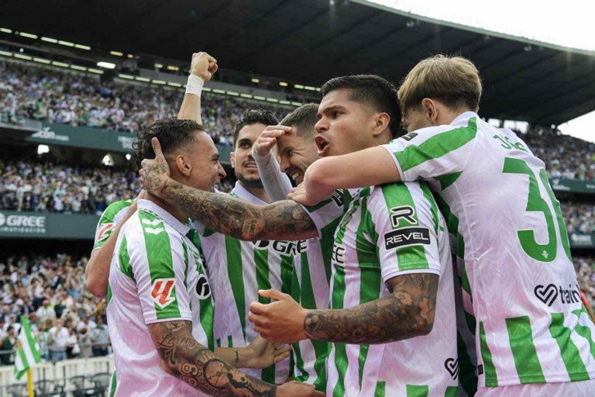 Real Betis' players celebrate after scoring their first goal during the Spanish league football match between Real Betis and Villarreal CF at the Benito Villamarin stadium in Seville on April 13, 2025.  CRISTINA QUICLER / AFP