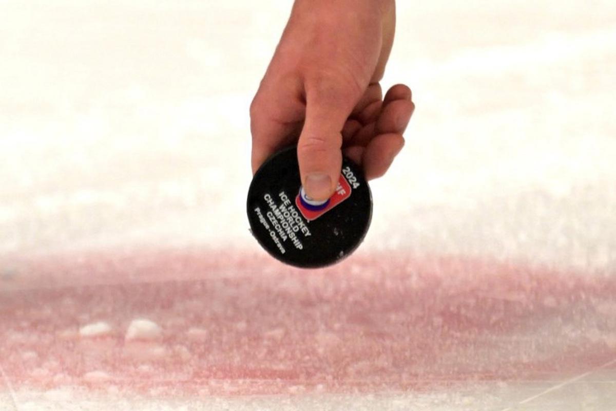 A referee lifts the puck during the IIHF Ice Hockey Men's World Championships match between USA and Germany in Ostrava, Czech Republic on May 11, 2024.  Joe Klamar / AFP