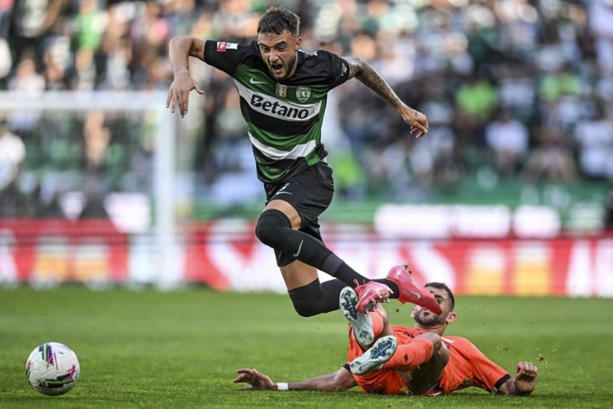 Sporting Lisbon's Belgian defender #06 Zeno Debast (L) is tackled by Vitoria Guimaraes' Portuguese forward #07 Nelson Oliveira during the Portuguese League football match between Sporting CP and Vitoria Guimaraes SC at Jose Alvalade stadium in Lisbon, on May 17, 2025.  Patricia DE MELO MOREIRA / AFP