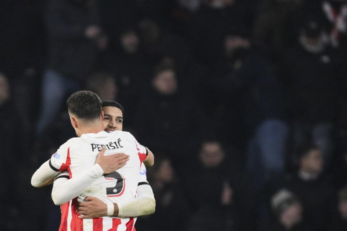 PSV Eindhoven's Moroccan midfielder #34 Ismael Saibari (R) celebrates with a teammate after scoring his team's first goal during the UEFA Champions League league phase day 8 football match between PSV Eindhoven and Bayern Munich at Philips Stadion in Eindhoven on January 28, 2026.  JOHN THYS / AFP