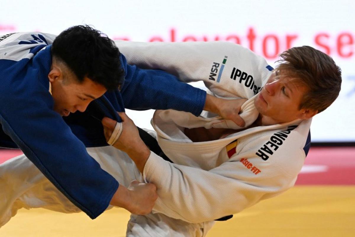 Belgiam's Matthias Casse (white) and Japan's Yuhei Oino (blue) compete in the men's -81kg category quarter-final match at the Tokyo Grand Slam judo competition in Tokyo on December 7, 2025.  Toshifumi KITAMURA / AFP