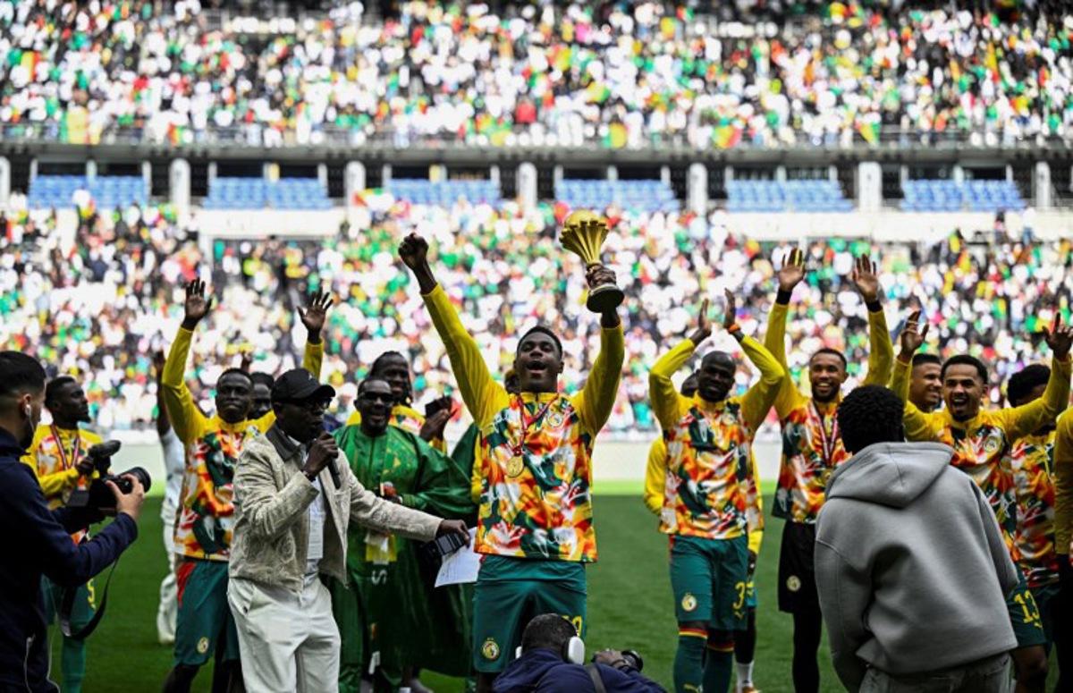 Senegal's players parade with The African Cup of Nations trophy ahead of the international friendly football match between Senegal and Peru at the Stade de France in Saint-Denis, north of Paris on March 28, 2026.   JULIEN DE ROSA / AFP