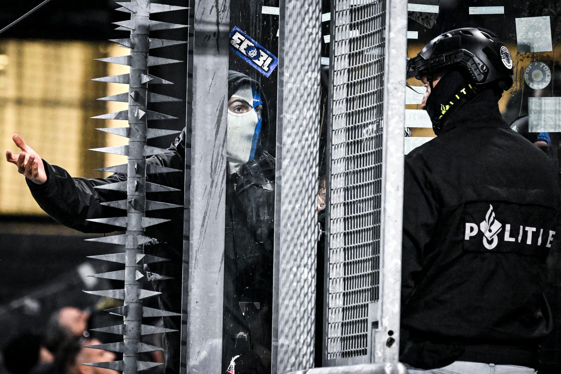 A masked Genk supporter provokes Dutch police ahead of a soccer game between Dutch soccer club FC Utrecht and Belgian KRC Genk, on Thursday 22 January 2026 in Utrecht, Netherlands, the seventh game (out of 8) in the league phase of the UEFA Europa League competition. BELGA PHOTO TOM GOYVAERTS