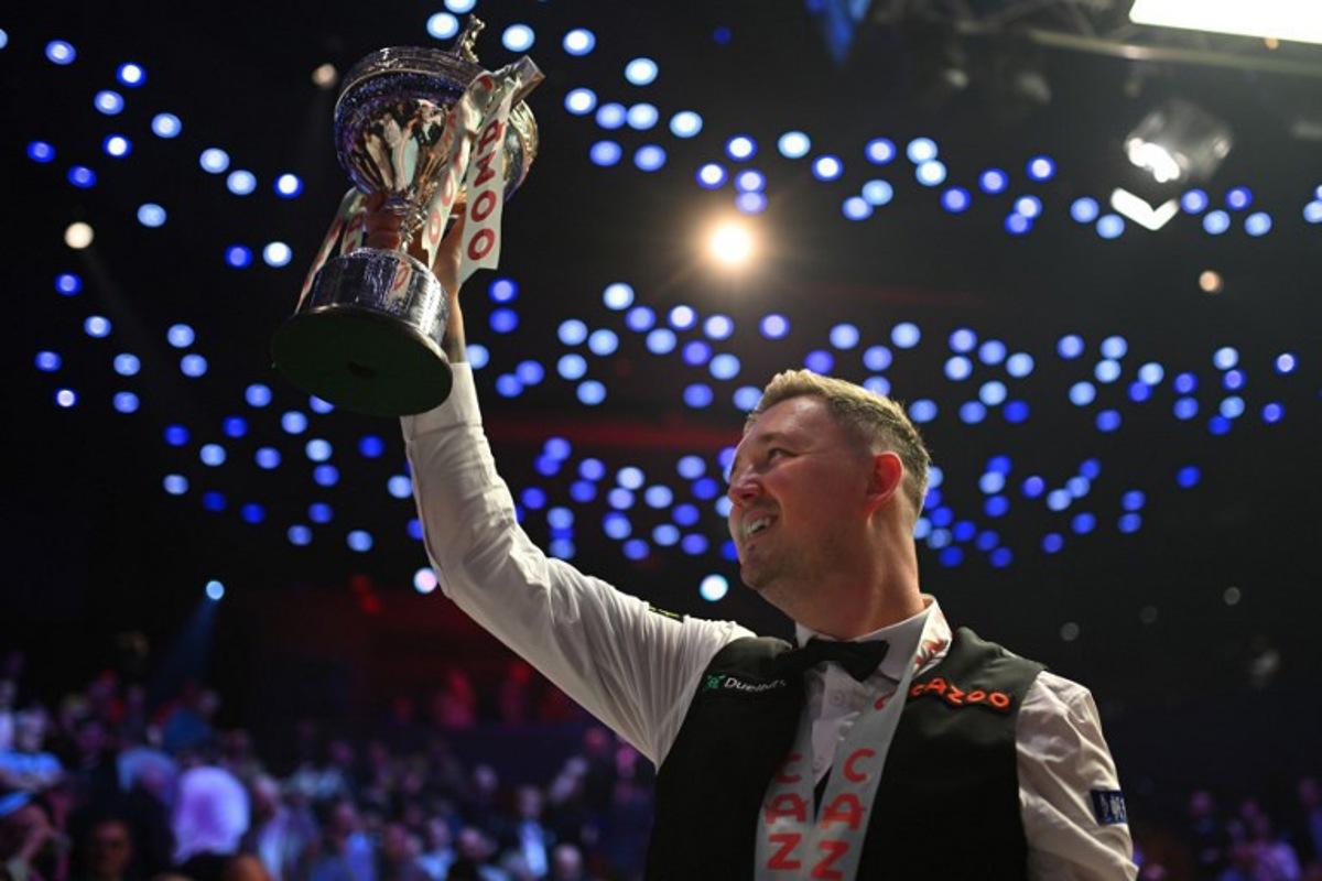 England's Kyren Wilson celebrates with the trophy after victory over Wales' Jak Jones on day two of their World Championship Snooker final at The Crucible in Sheffield, northern England on May 6, 2024.  Wilson won the final 18-14. Oli SCARFF / AFP
