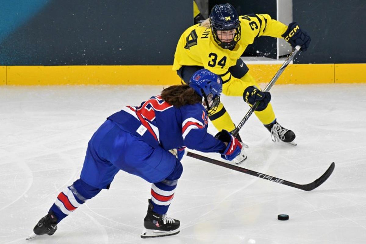 USA's forward #12 Kelly Pannek (front) fights for the puck with Sweden's #34 Mira Hallin during the women's play-off semi-final ice hockey match between USA and Sweden at the Milano Santagiulia Ice Hockey Arena during the Milano Cortina 2026 Winter Olympic Games in Milan, on February 16, 2026.  Alexander NEMENOV / AFP