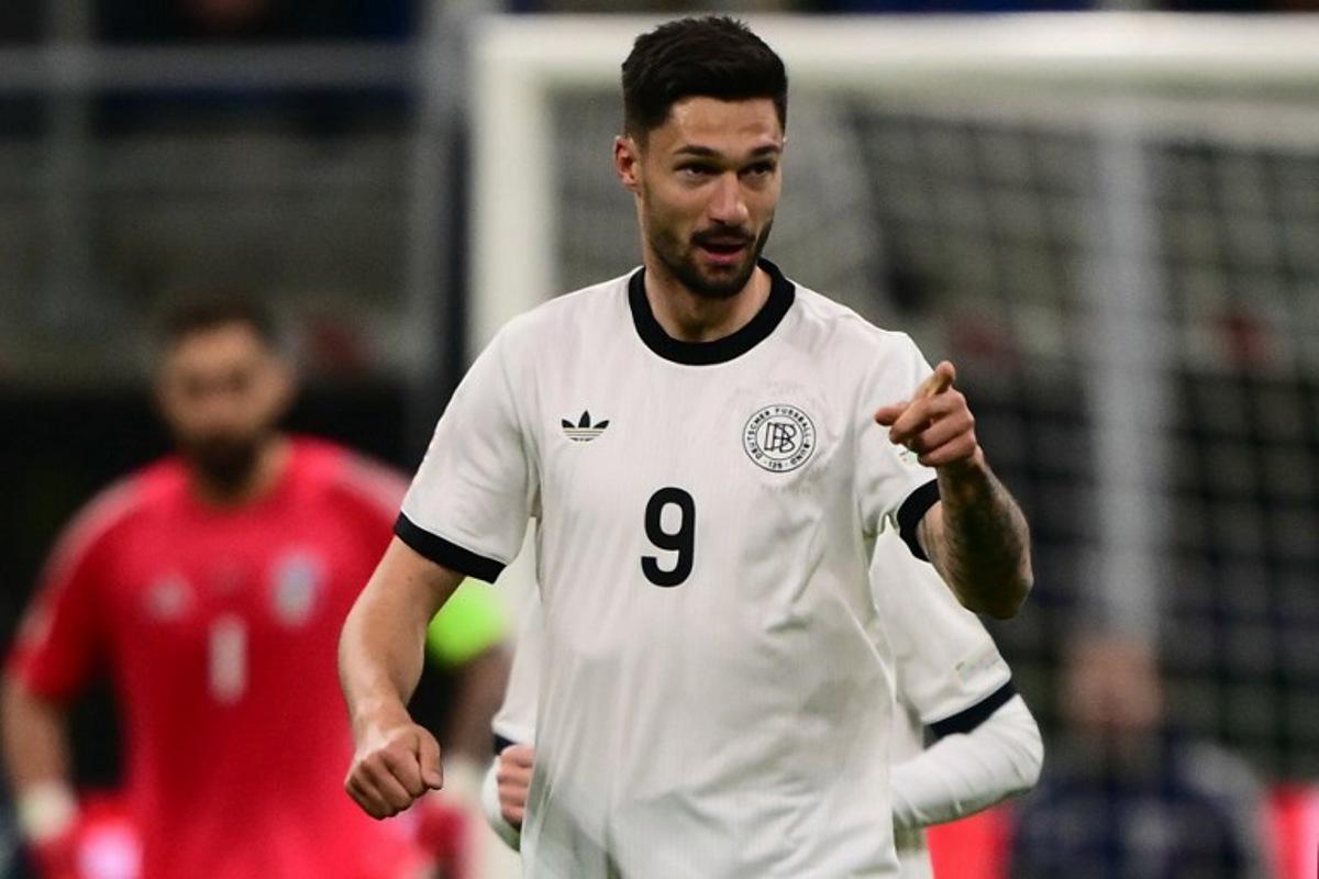 Germany's forward #09 Tim Kleindienst celebrates after scoring his team's first goal during the Nations League quarter final first leg football match between Italy and Germany at the San Siro Stadium in Milan, on March 20, 2025.  Marco BERTORELLO / AFP