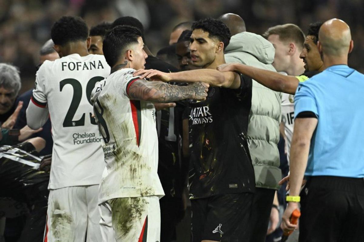 Paris Saint-Germain's Moroccan defender #02 Achraf Hakimi (C) holds Chelsea's Argentine midfielder #08 Enzo Fernandez after Chelsea's Portuguese forward #07 Pedro Neto (not in picture) pushed a ballboy during the UEFA Champions League round of 16 first leg football match between Paris Saint-Germain (PSG) and Chelsea at the Parc des Princes stadium in Paris on March 11, 2026.  JULIEN DE ROSA / AFP