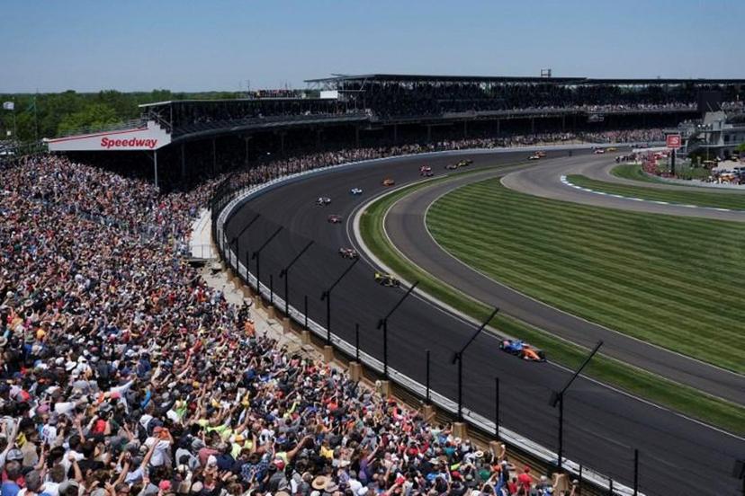 Drivers move into turn one during the Indianapolis 500 auto race at Indianapolis Motor Speedway, May 30, 2021 in Indianapolis. Brazil's Helio Castroneves matched the all-time record by winning his fourth career Indianapolis 500 on Sunday, holding off Alex Palou over the final laps for the victory at age 46. Castroneves -- who also won in 2001, 2002 and 2009 -- joined US legends AJ Foyt, Al Unser Sr and Rick Mears as four-time winners over 200 laps at the famed 2.5-mile (4km) Indianapolis Motor Speedway oval.  Jeff Dean / AFP